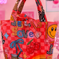 Colorful tote bag with cartoon designs on a pink background